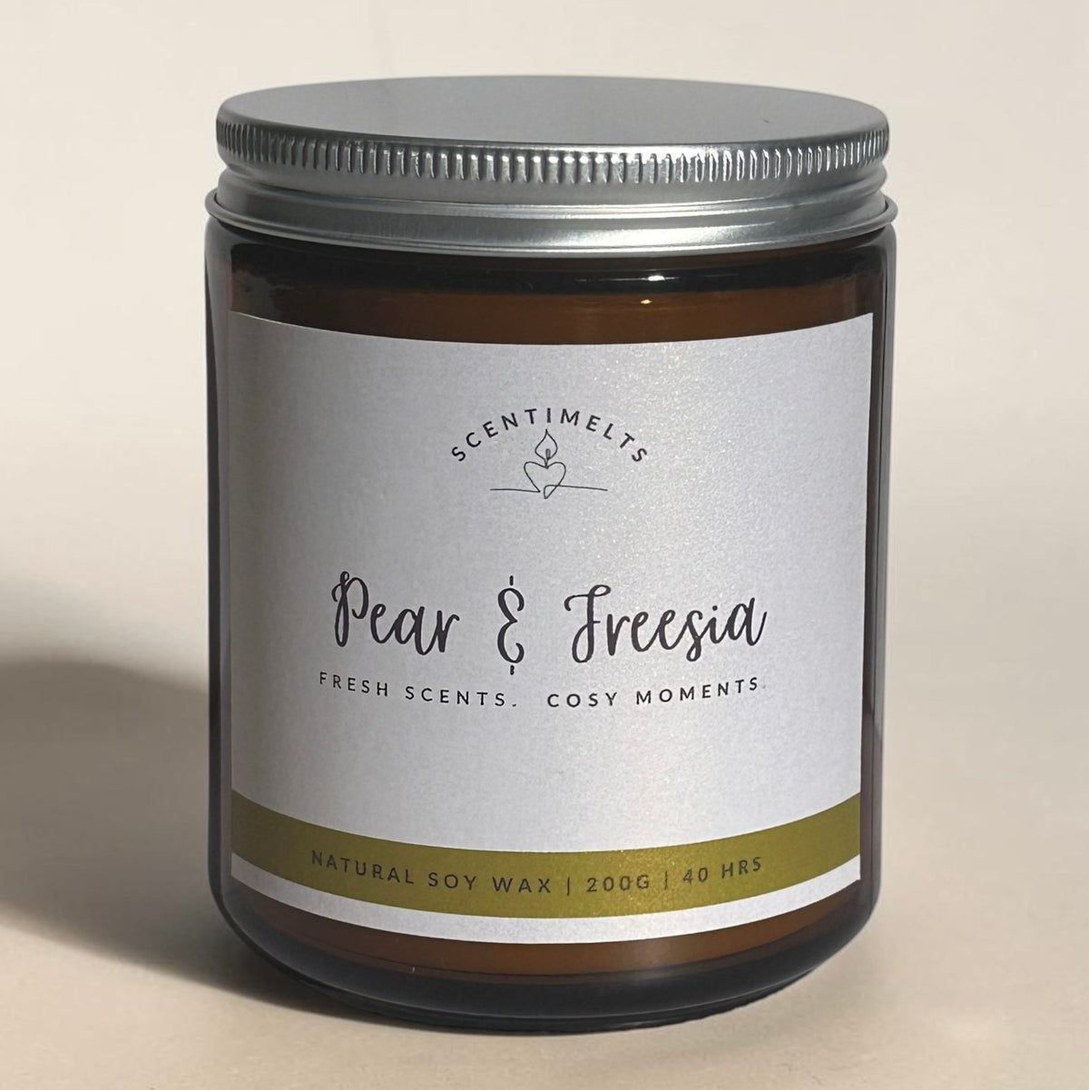 Scentimelts Pear & Freesia candle jar on a beige background