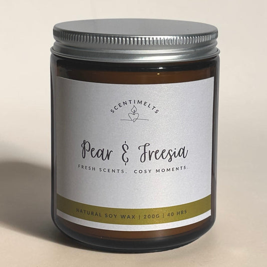 Candle jar labeled 'Pear & Freesia' by Scentimentals on a beige background