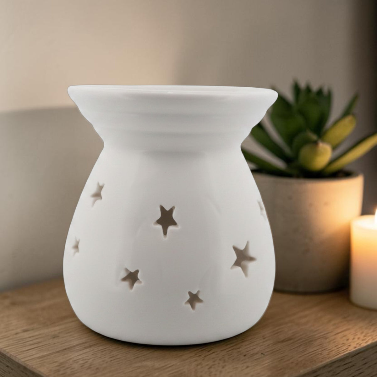 Serene White ceramic wax melt burner with star cut-out details glowing softly
