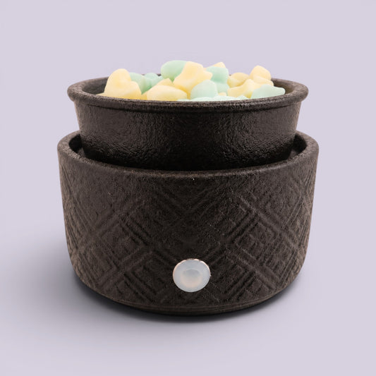 Textured Matte Black Electric Warmer filled with pastel yellow and green wax pieces