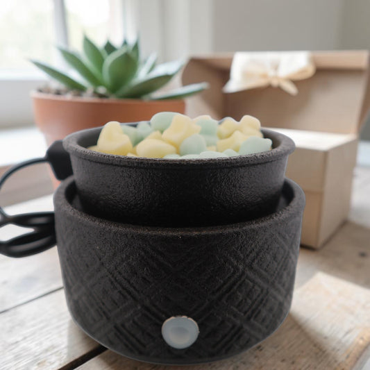 Matte black ceramic electric wax warmer with textured finish, dish showing melted wax.