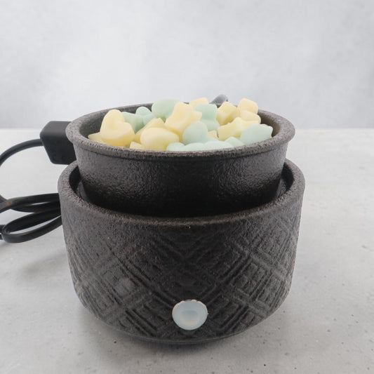 Matte black electric warmer with power cable, close-up of the textured ceramic body.